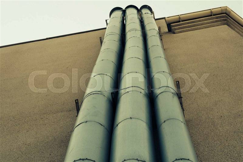 The pipes on the outside wall of the building. Retro colors. Bottom view, stock photo