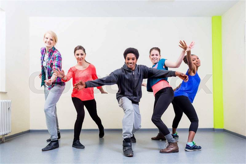 Group of young people having dance class in gym, stock photo
