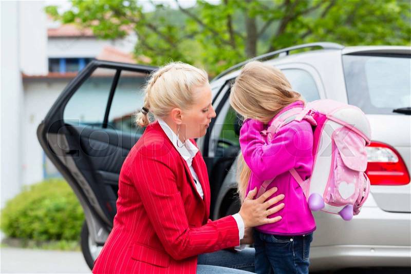 Mother consoling daughter on first day at school, the kid being a bit afraid of what may lay ahead, stock photo