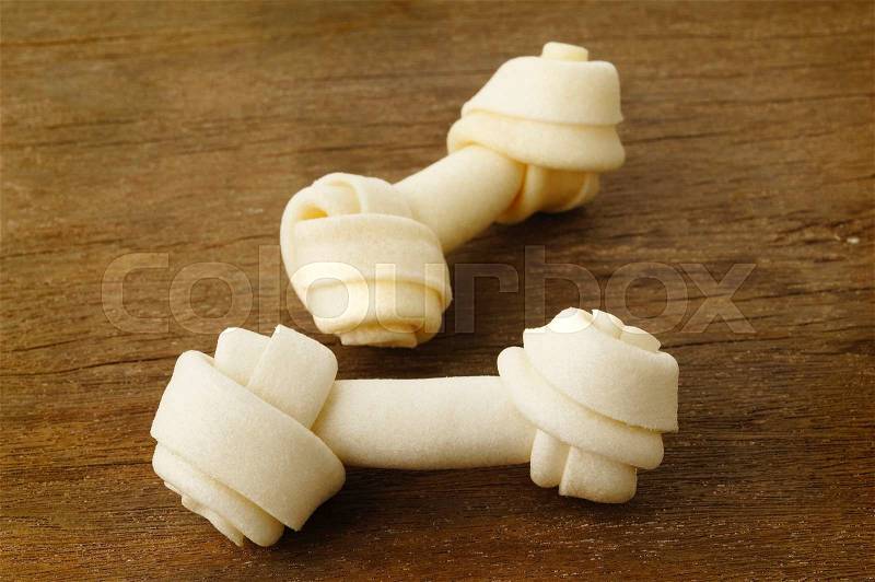 Bone toy for dogs on wooden background, stock photo