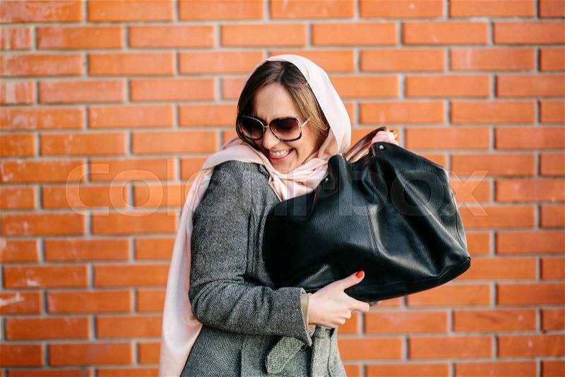 Young beautiful happy girl very satisfied with a new bag, stock photo