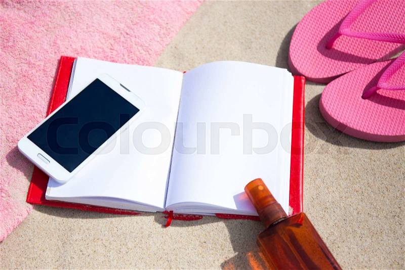 Summer concept - notepad and smart phone on the beach, stock photo
