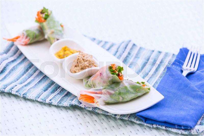 Vietnamese vegetable spring rolls served with walnut pate and mango sauce on a plate. Oriental vegetarian food, healthy eating choice, stock photo
