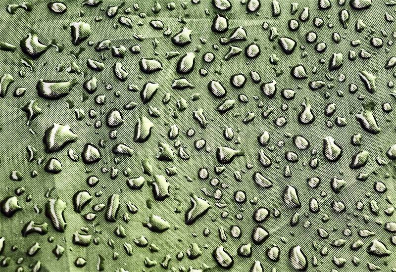 Abstract background with green water drops on the rough fabric, stock photo