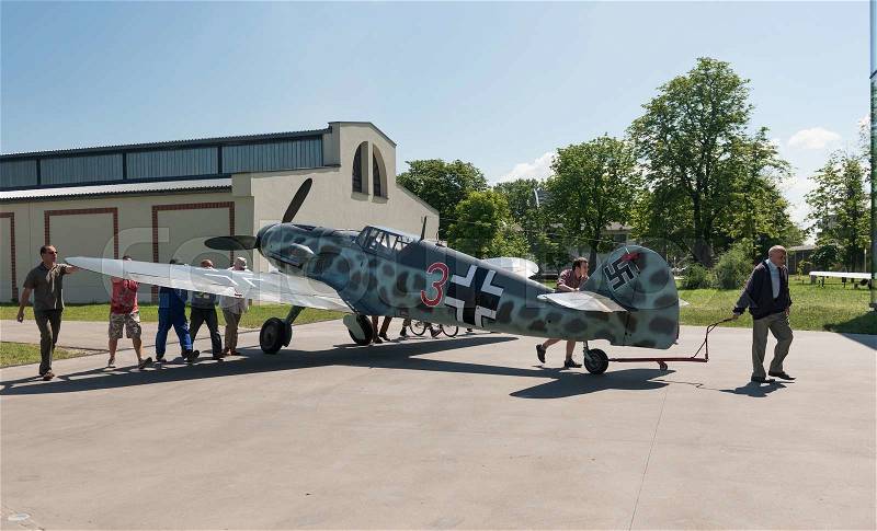 KRAKOW MUSEUM OF AVIATION, POLAND - JUL, 2015: Exhibition plane in the aviation Museum in Krakow, Poland on July, 2, 2015. Museum workers roll the plane to the exhibition pavilion, stock photo