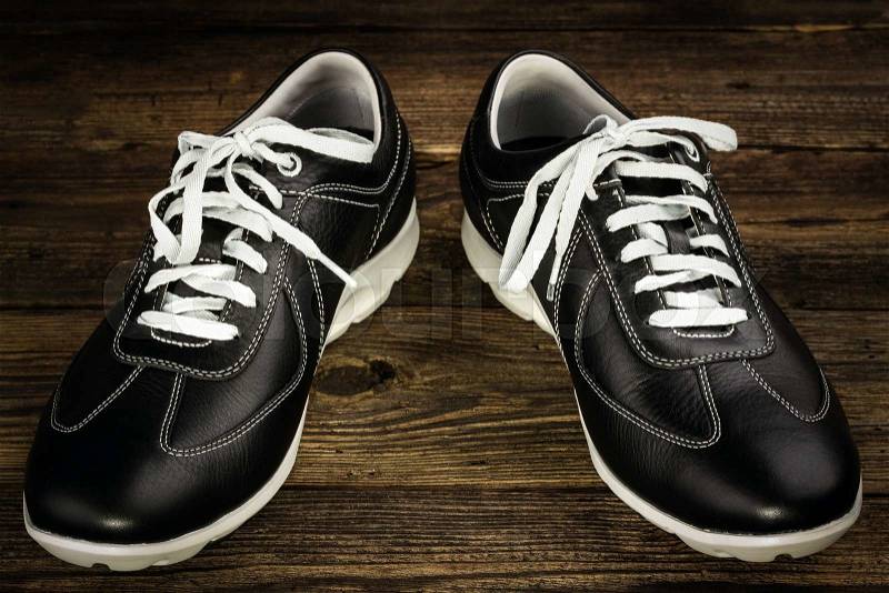 Black leather man\'s shoe on wooden background, stock photo