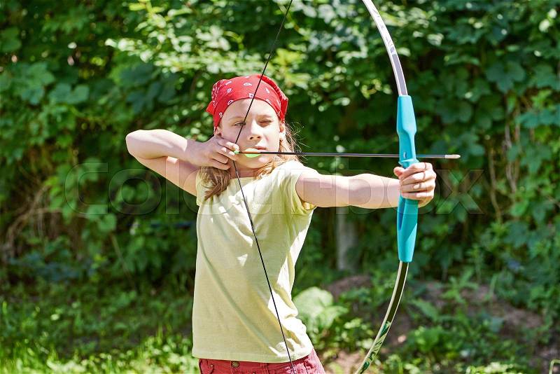 Girl with bow shooting to sport aim in sunny summer day, stock photo