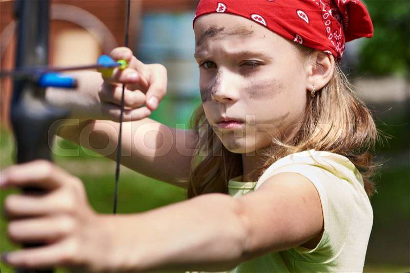 Girl archer with bow shooting to sport aim in sunny summer day, stock photo