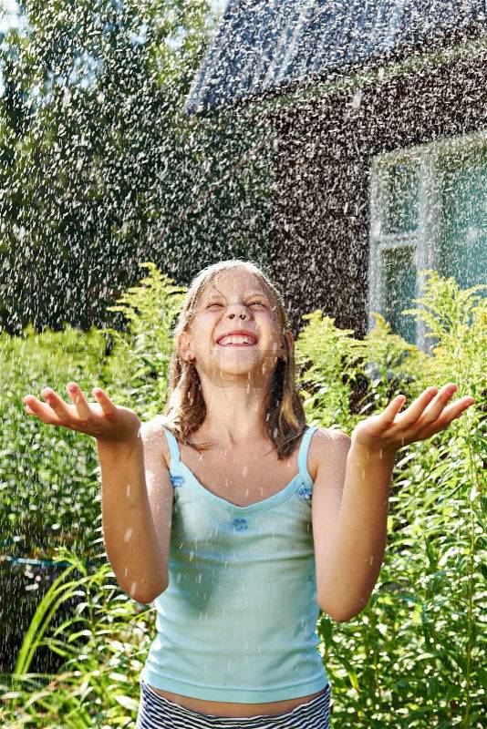Happy girl under summer rain, stock photo