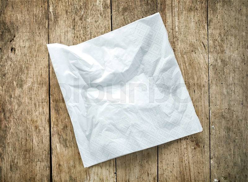 White paper napkin on old wooden table, stock photo