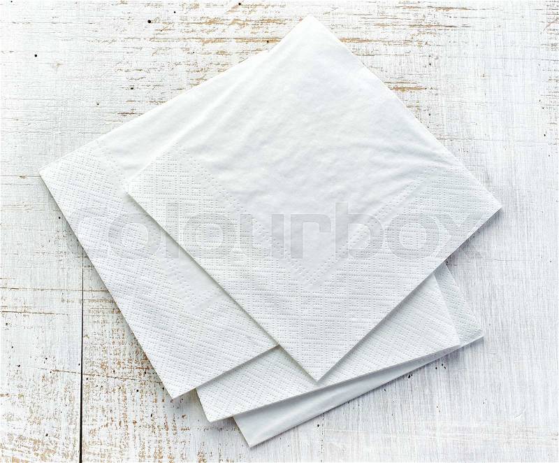 White paper napkins on old wooden table, stock photo