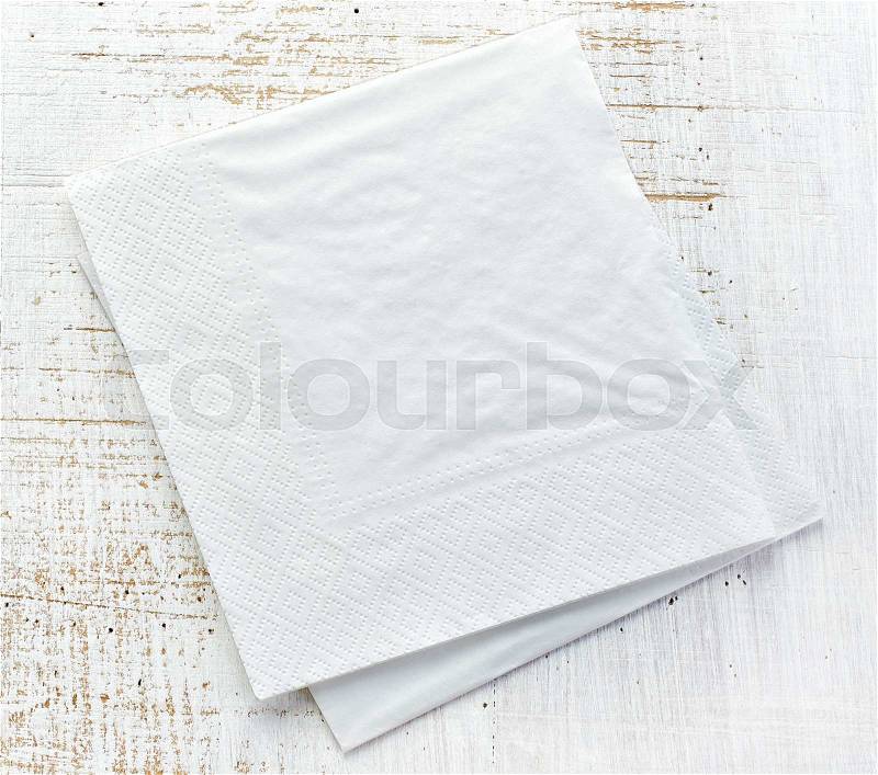 White paper napkins on old wooden table, stock photo