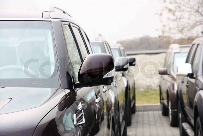Group of cars stand in one number of dark color, stock photo
