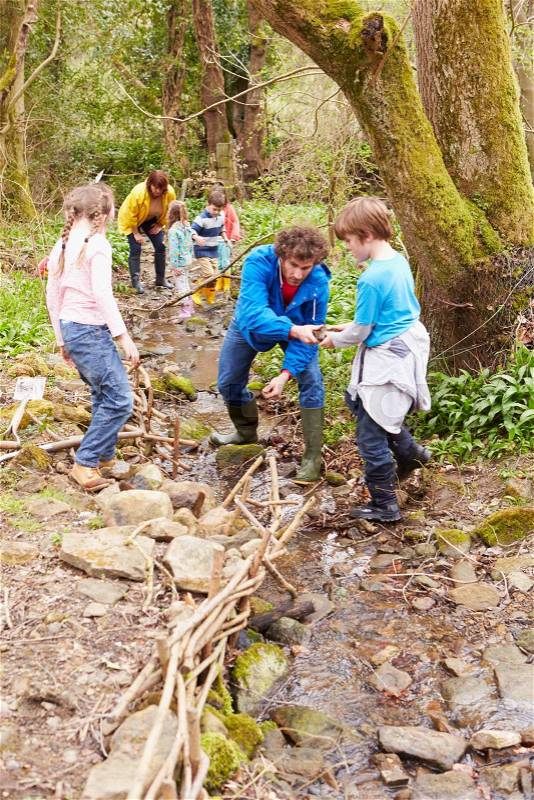 Children And Adults Carrying Out Conservation Work On Stream, stock photo