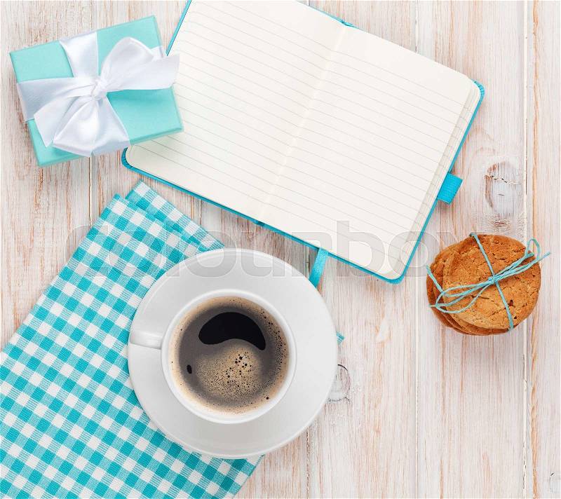 Gift box, coffee, cookies and notepad on white wooden table with copy space, stock photo