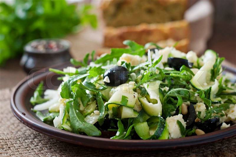 Zucchini salad with feta, olives and pine nuts, stock photo