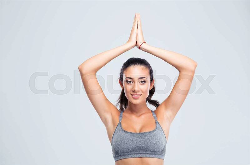Happy fitness woman with joined hands over head isolated on a white background. Looking at camera, stock photo