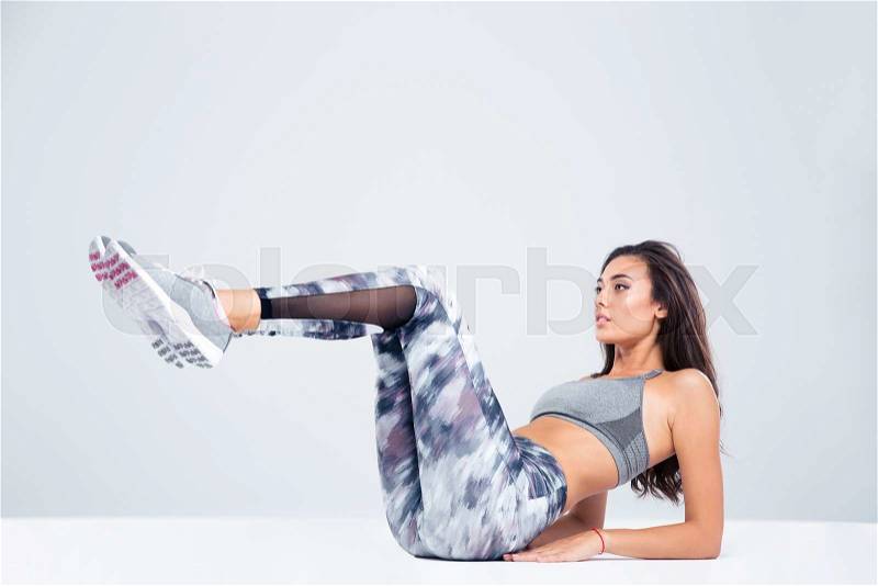 Portrait of a sports woman doing abs exercises isolated on a white background