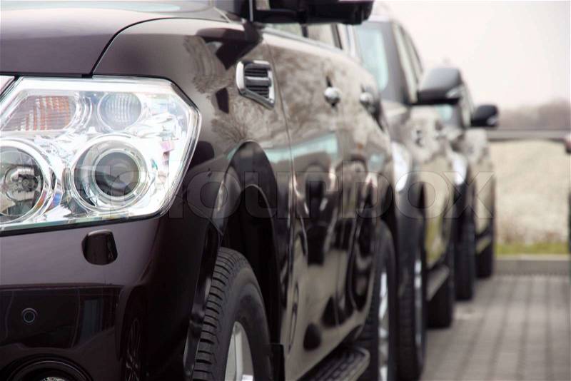 Group of cars stand in one number of dark color, stock photo