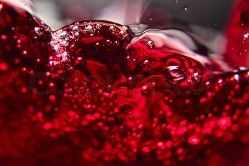 Red wine on black background, abstract splashing, stock photo
