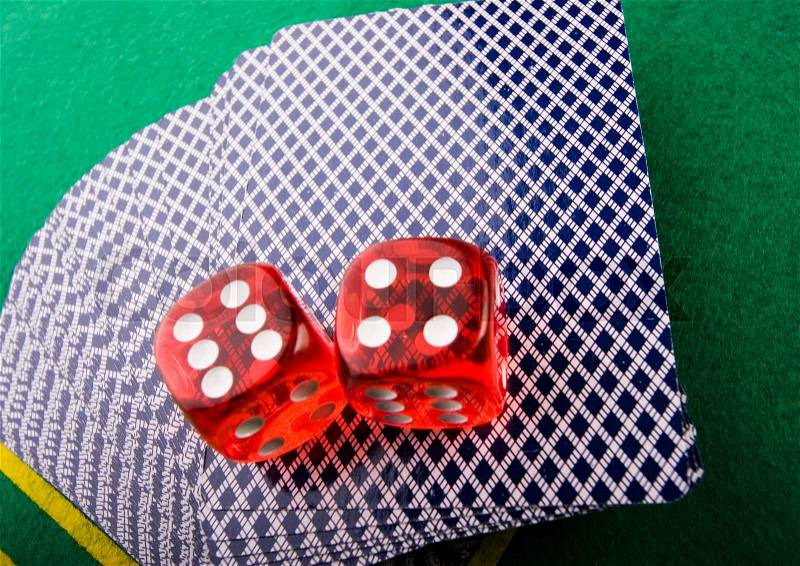 Dice on cards in casino, ambient light saturated theme, stock photo