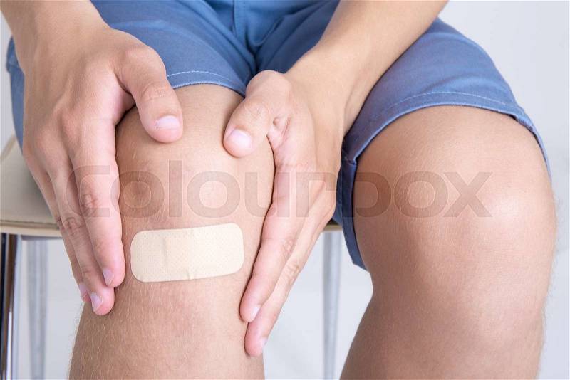 Young man with adhesive bandage on his knee, stock photo