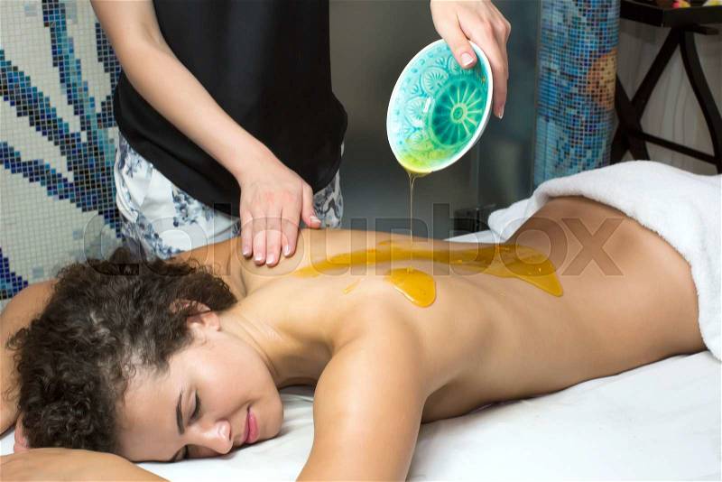 Processes honey massage girl in a spa salon, stock photo