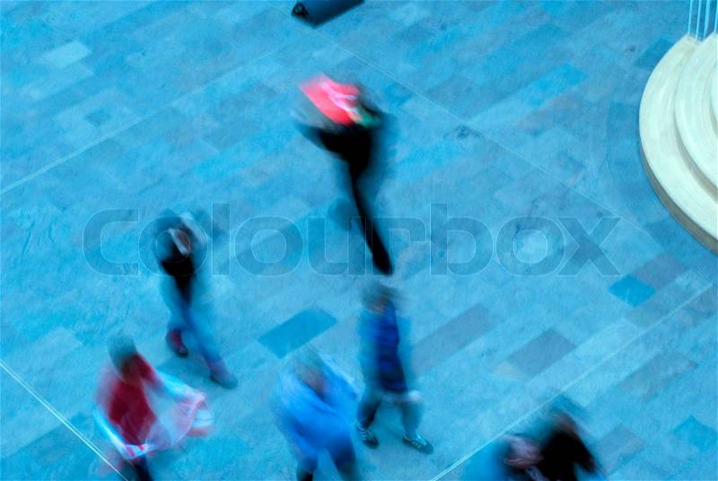 Blurred blue people walking inside a big building in Copenhagen, Denmark, stock photo