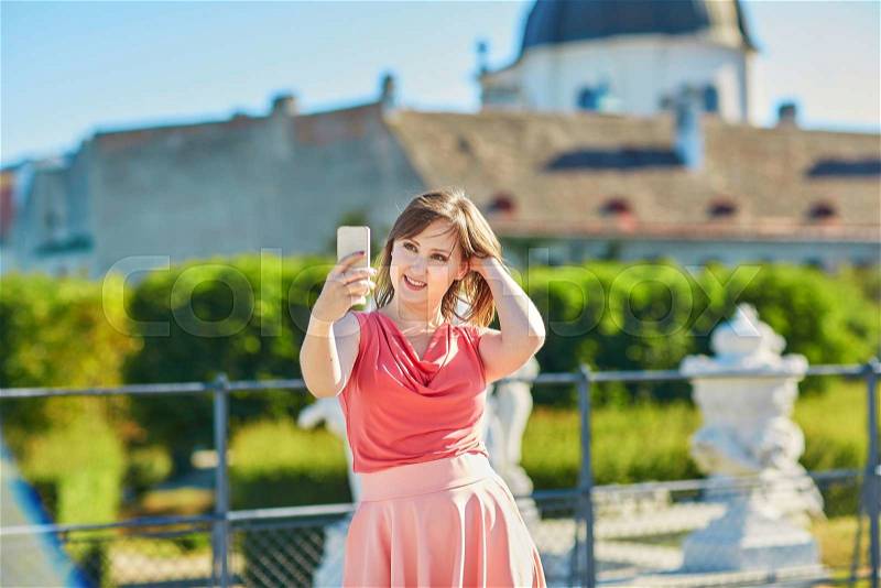 Beautiful young tourist walking in the street in Vienna, Austria and taking selfie, stock photo