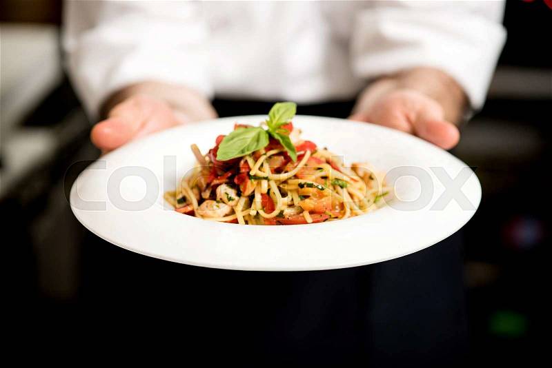 Chef holding hot spaghetti to serve in the restaurant, stock photo