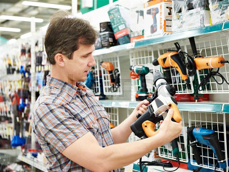 Man shopping for perforator in hardware store close-up, stock photo
