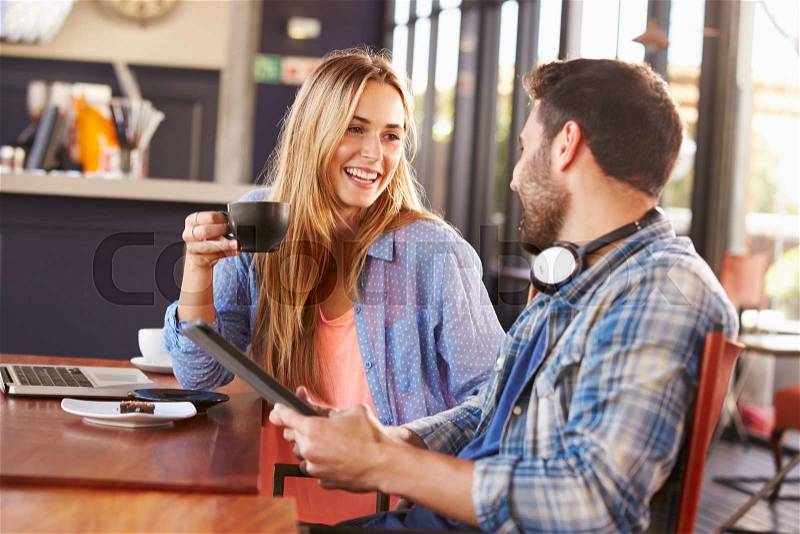 Young man and woman meeting at a coffee shop, stock photo