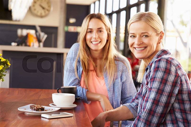 Two female friends meeting at a coffee shop, stock photo