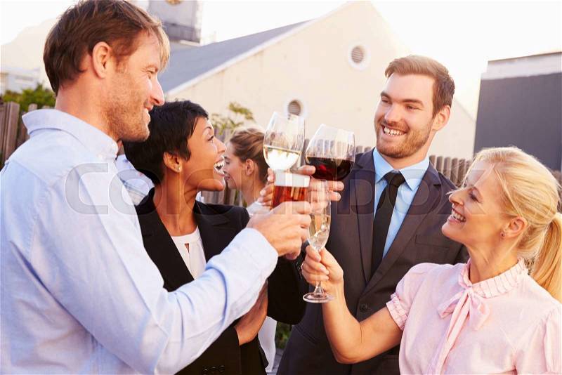 Colleagues drinking after work at a rooftop bar, stock photo