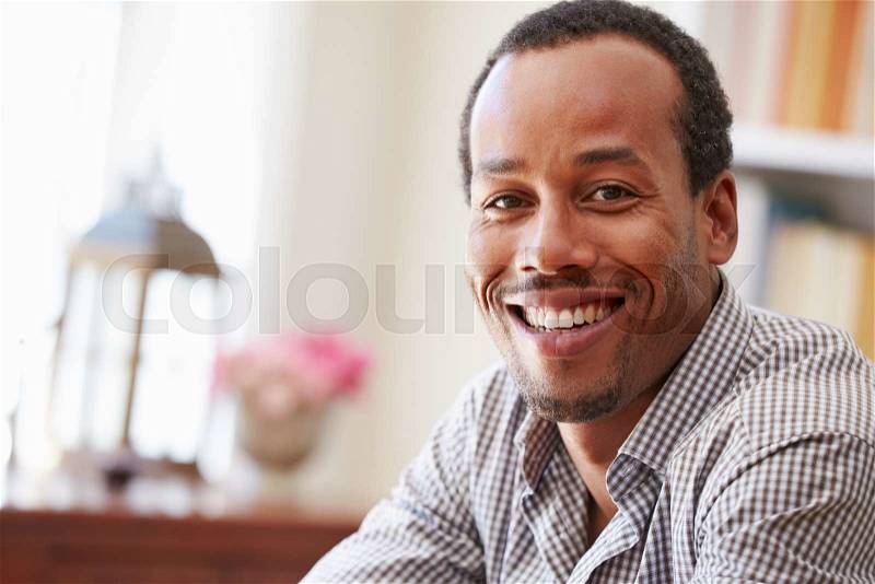 Portrait ofÿa smiling young man sitting in a room, stock photo