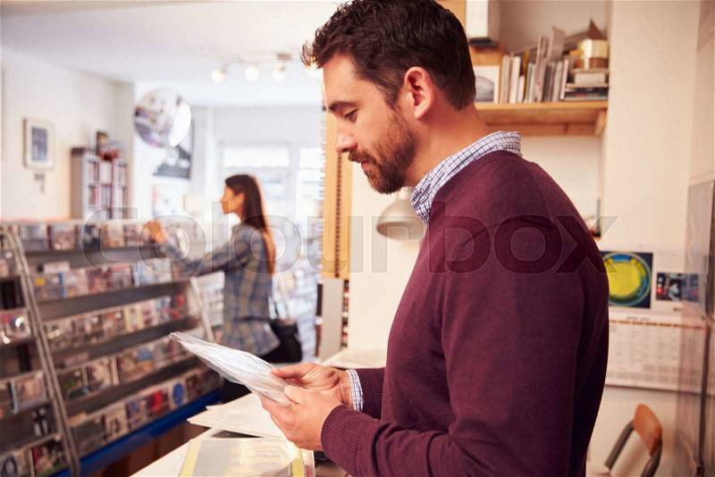 Man working behind the counter at a record shop, stock photo