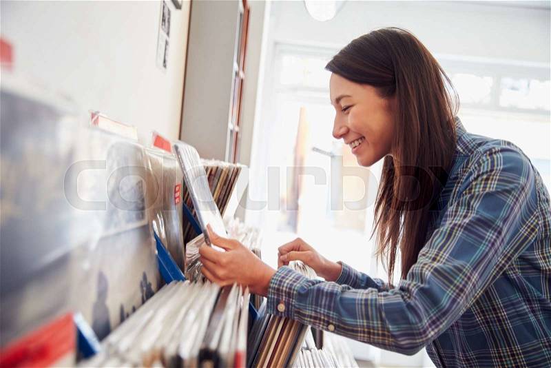 Woman selecting records at a record shop, stock photo