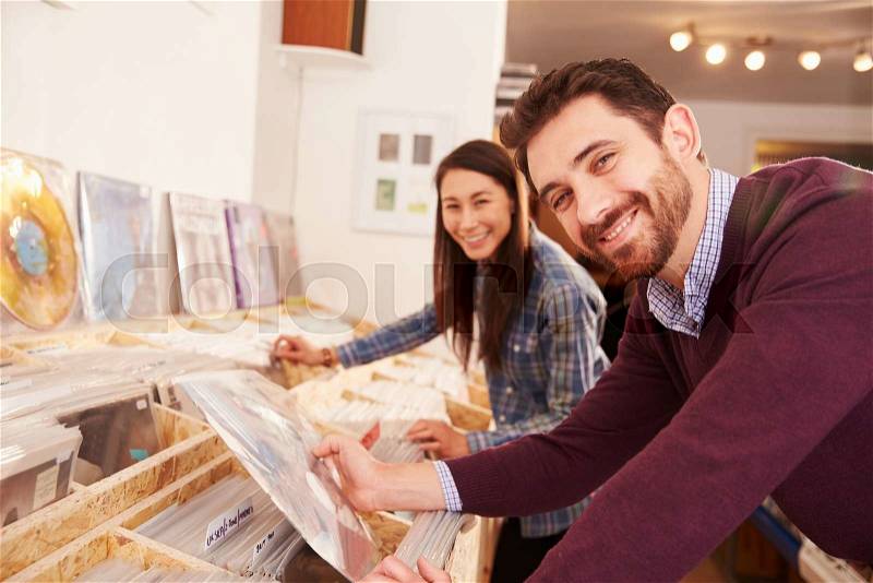 Two people browsing records at a record shop, portrait, stock photo