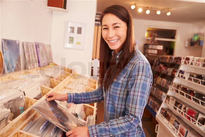 Woman selecting a record in a record shop, portrait, stock photo
