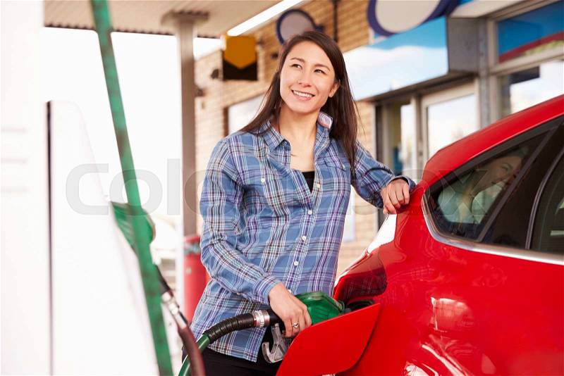 Woman man refuelling a car at a petrol station, stock photo