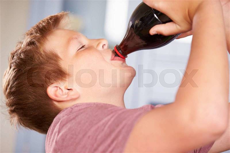 Close Up Of Boy Drinking Soda From Bottle, stock photo