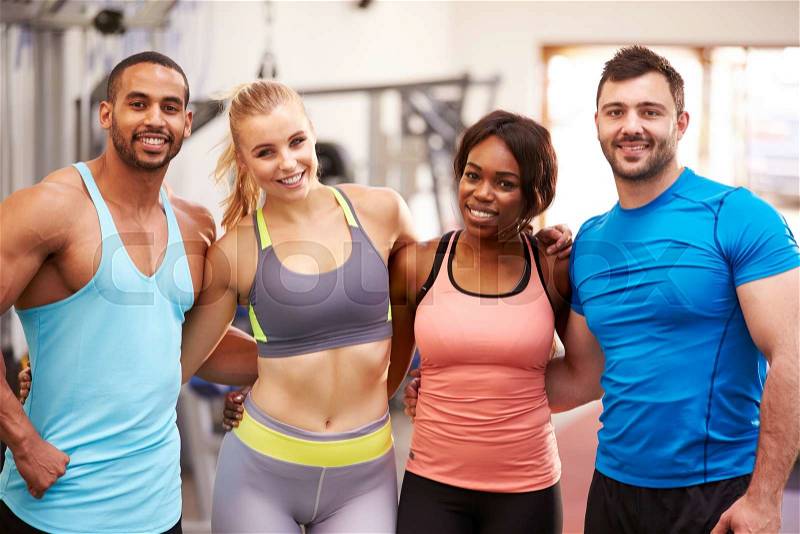 Happy group of gym buddies with arms around each other, stock photo