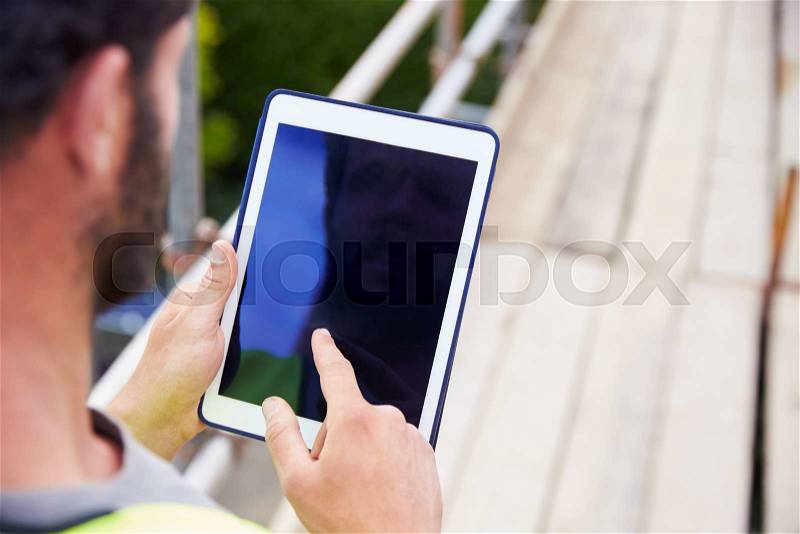 Construction Worker Using Digital Tablet On Building Site, stock photo