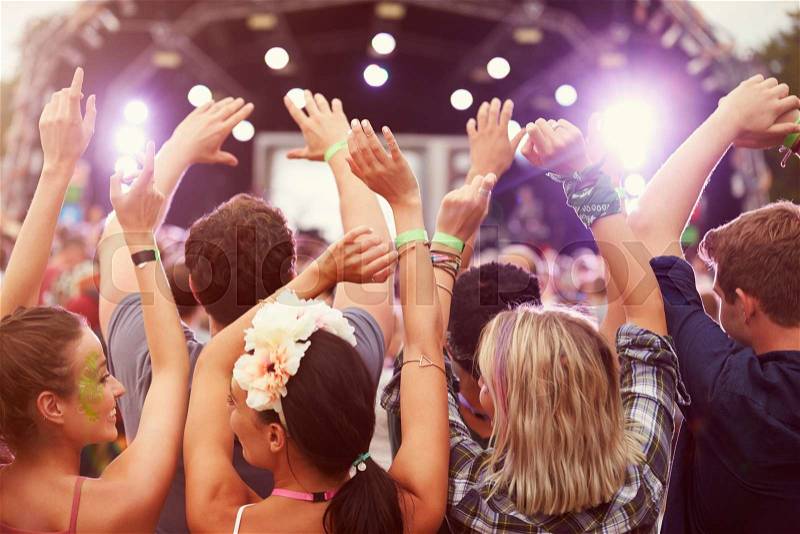 Audience with hands in the air at a music festival, stock photo