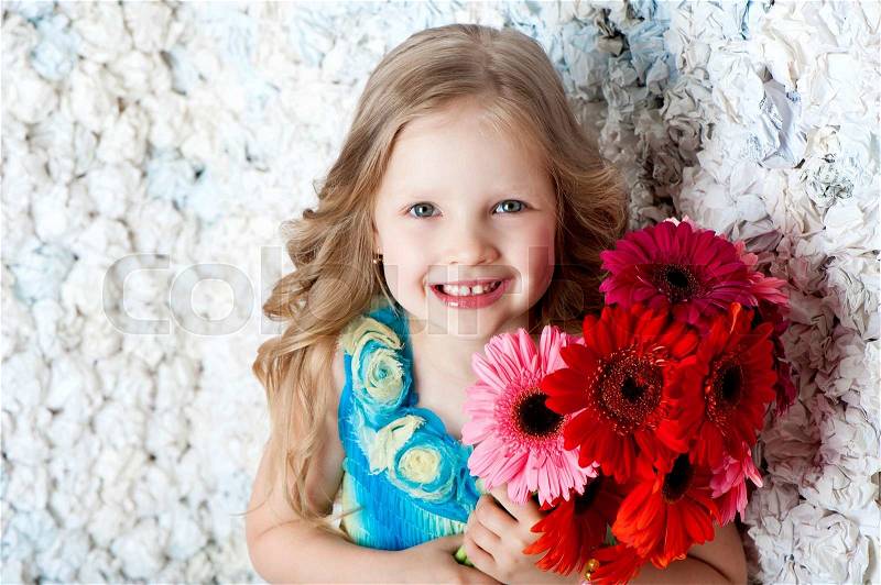 Beautiful long haired girl with flowers in color dress, stock photo