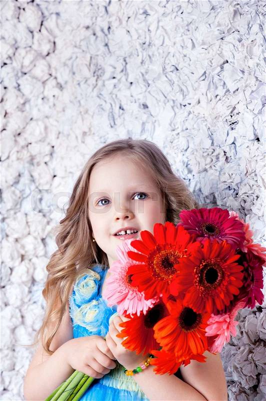 Beautiful long haired girl with flowers in color dress, stock photo