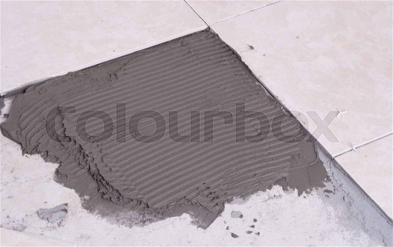 Notched trowel, spacers and prepared setting compound for tile, stock photo