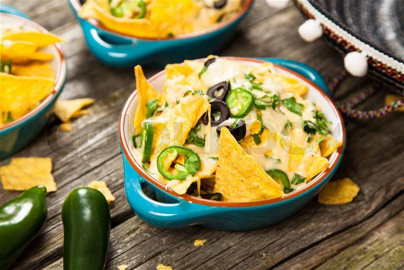 Nachos with melted cheese and salsa, guacamole and cheese dips, stock photo