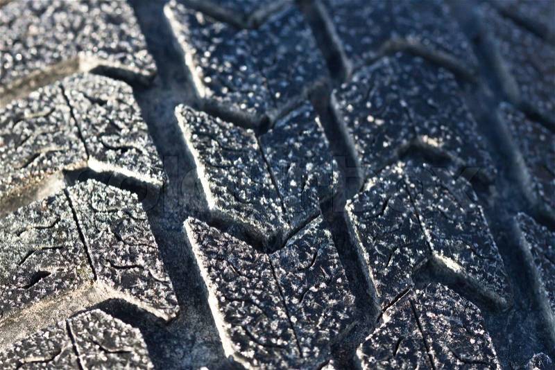 Winter tyre close-up with ice and snow, it is time to buy a winter rubber, stock photo