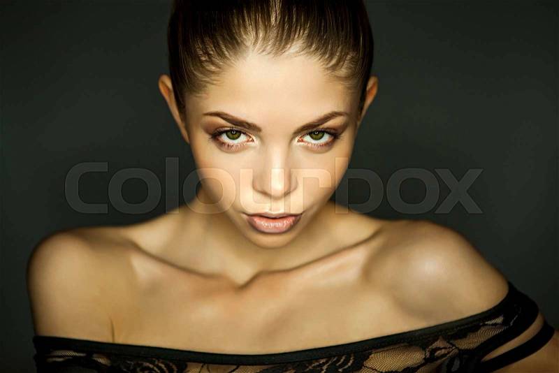 Portrait of beautiful woman in elegant blouse poses gesticulating with arms on black background.Studio shot.Well-groomed skin.Fashion look.Perfect makeup.Brown eye shadows.Clean skin.Stylish image.Brunette.Gentle hands,shoulders,curves of body.Skinny, sto